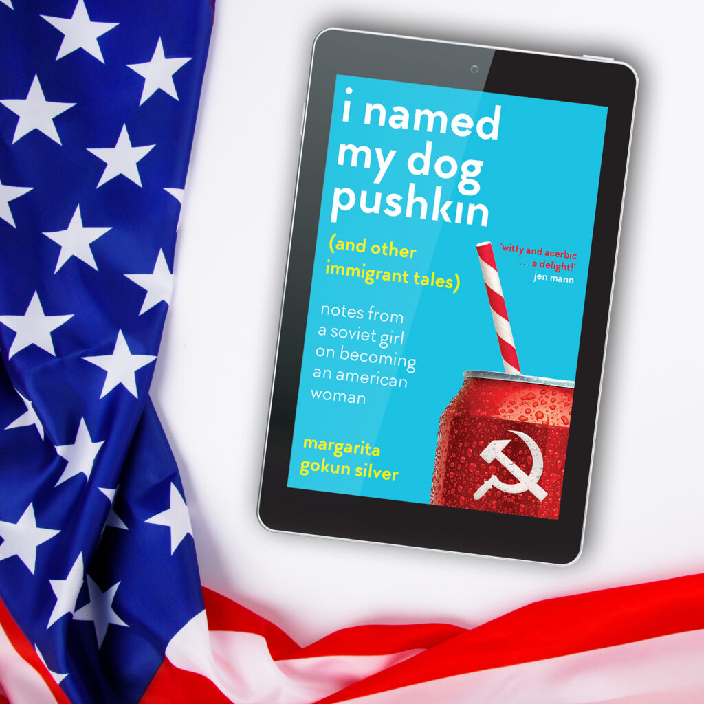 An American flag lies next to an ereader showing a book cover for I Named My Dog Pushkin